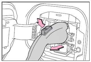Subaru Solterra removing AC charging connector by pressing latch release button
