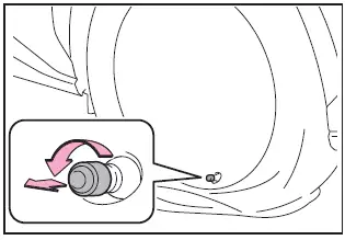 Subaru Solterra removing valve cap from punctured tire